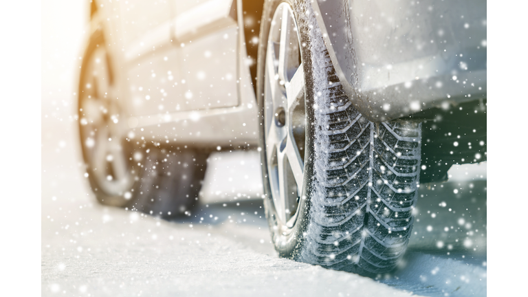 Close-up of car wheels rubber tires in deep winter snow. Transportation and safety concept.