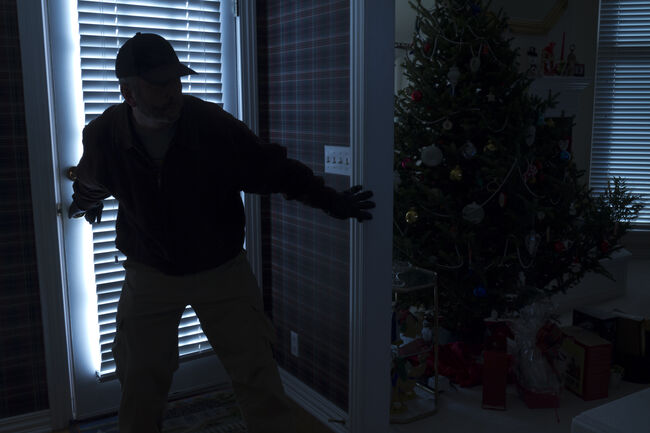 Silhouette of burglar breaking into house at Christmas