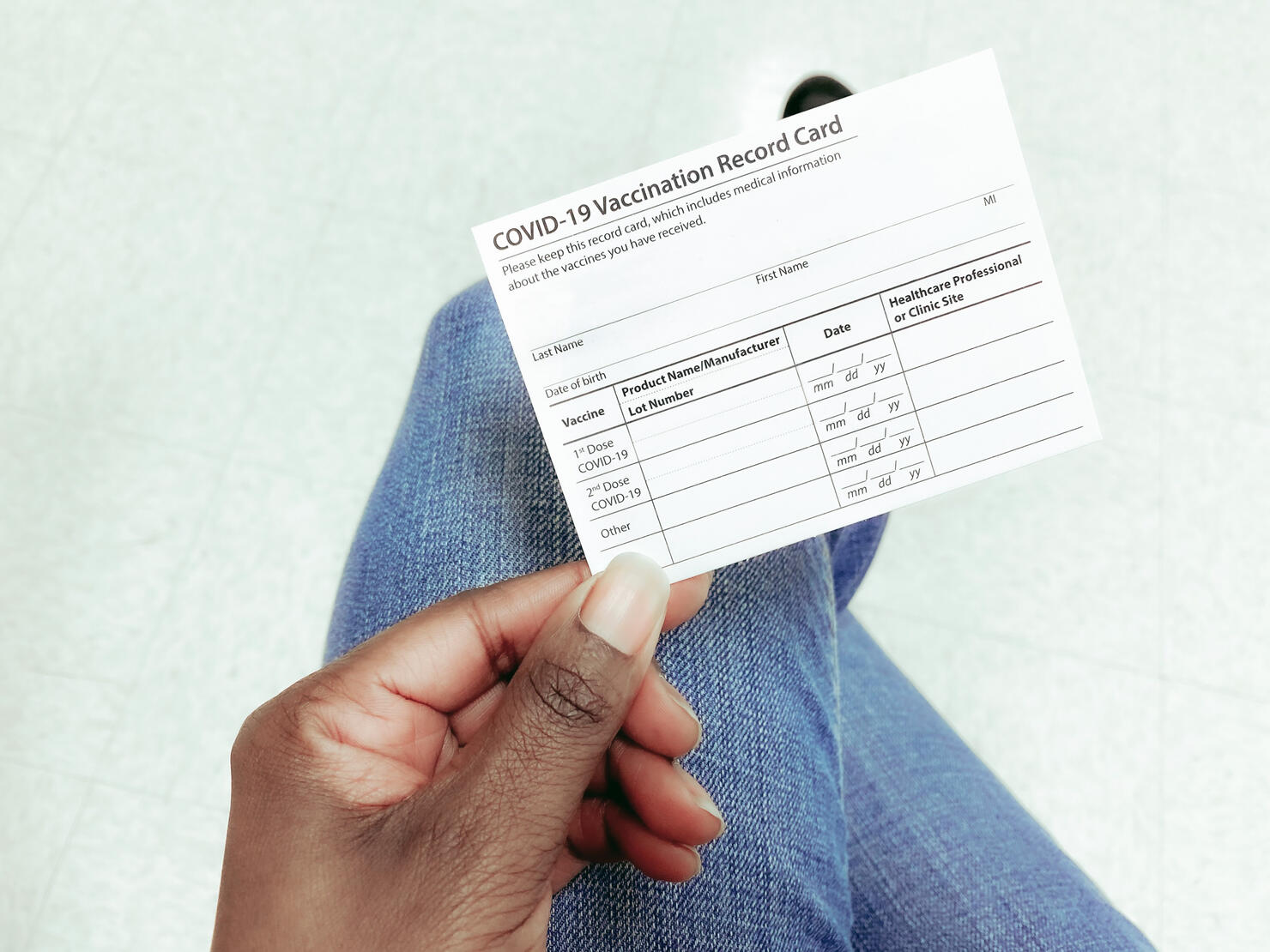 Woman Holds COVID-19 Vaccination Record Card