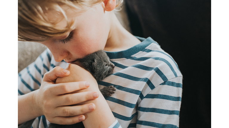 Boy holding a Tiny Newborn Kitten