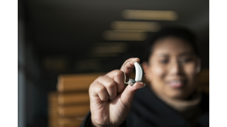 Woman holding hearing aid