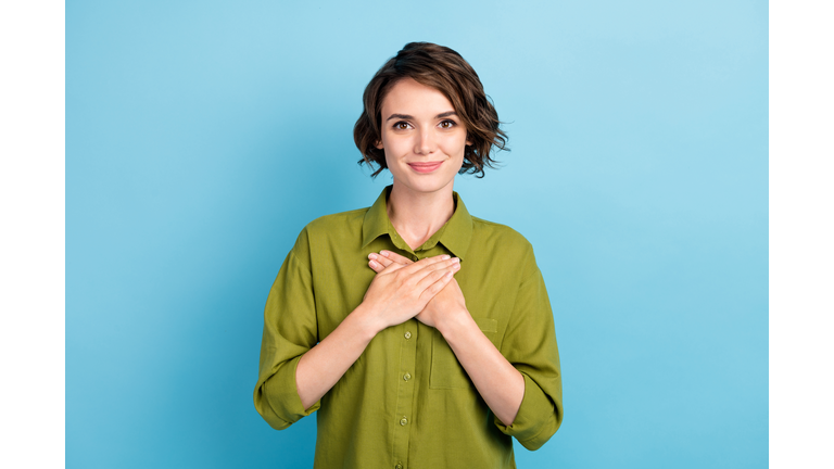 Photo of lovely lady short hairstyle hands chest smile peaceful rest comfortable cozy spring wear green shirt isolated blue color background