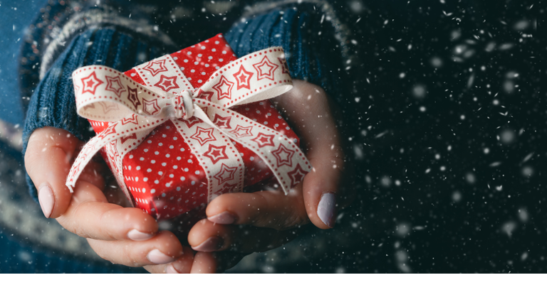 Close up shot of female hands holding a small gift