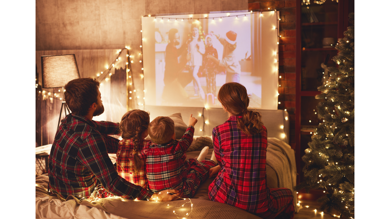 family mother father and children watching projector, film, movi