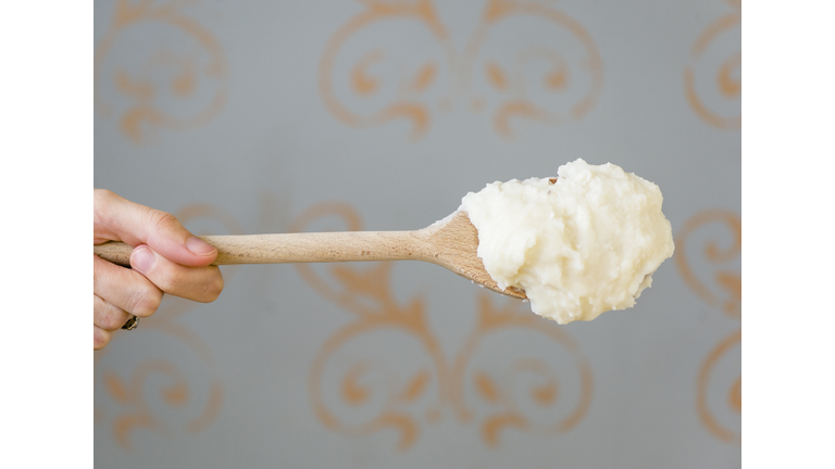 Close up of mashed potatoes on wooden spoon