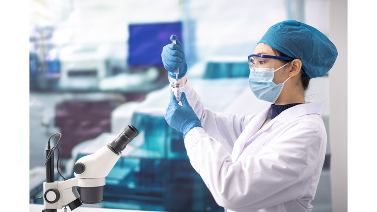 A young woman doctor studies the Covid-19 vaccine in the lab