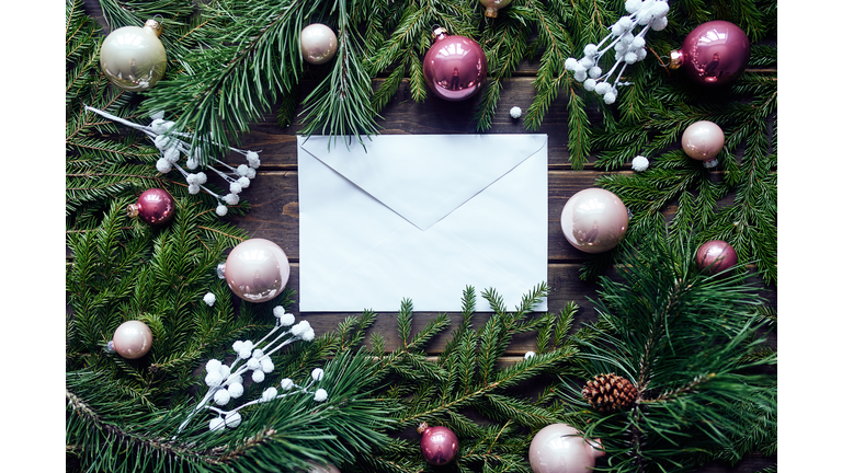 A beautiful New Year and Christmas card with Christmas tree branches and Christmas balls with an envelope