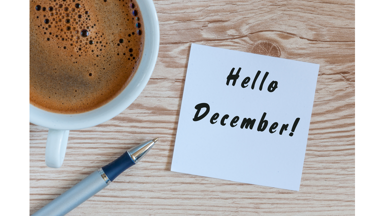 Hello December written on paper near morning coffee cup at