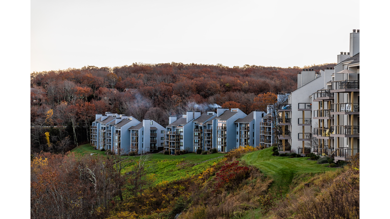 Wintergreen, Virginia at morning sunrise with autumn fall foliage trees by apartment condo building balconies at ski resort town village on mountain peak