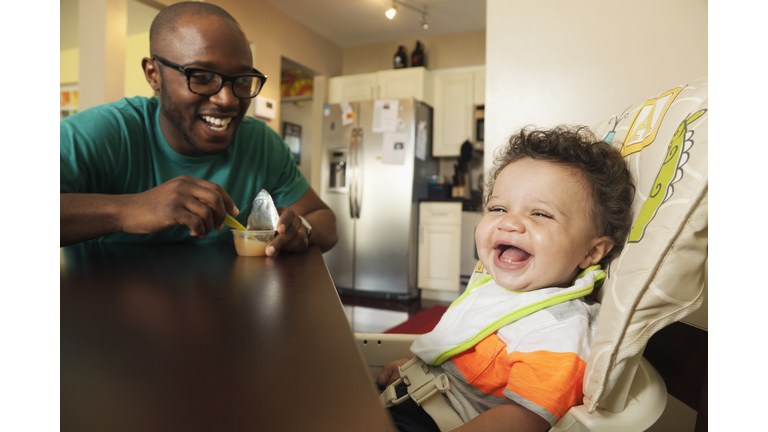 Father feeding baby at table