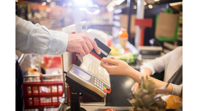 Man Paying with Credit Card in Supermarket