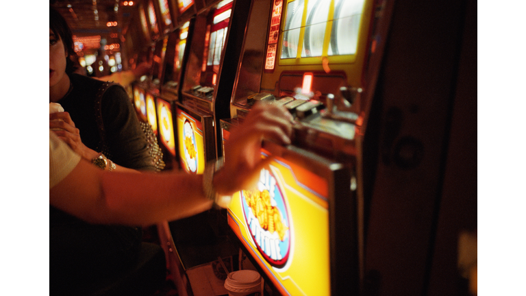 Couple playing slot machine in casino, Las Vegas, Nevada, USA