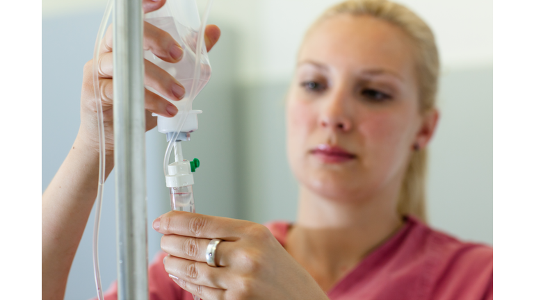 female medical assistant prepares an infusion - focus on foreground