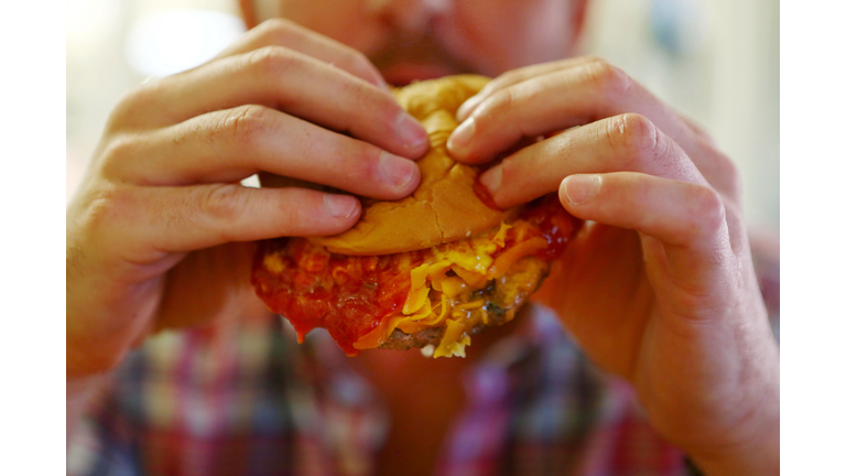 A Man Eating A Burger