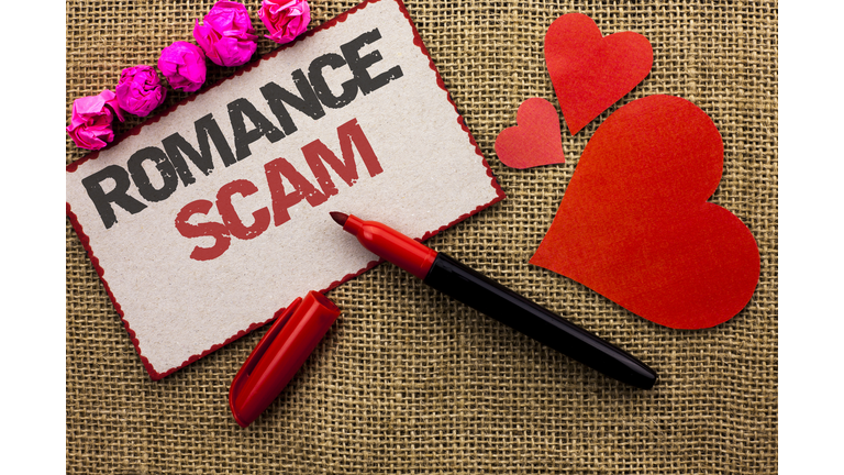 Word writing text Romance Scam. Business concept for Dating Cheat Love Embarrassed Fraud Cyber Couple Affair written on Cardboard Piece on the jute background Marker and Hearts next to it.