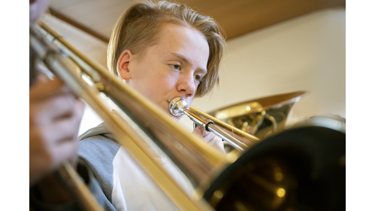 Young teenage boy playing the trombone