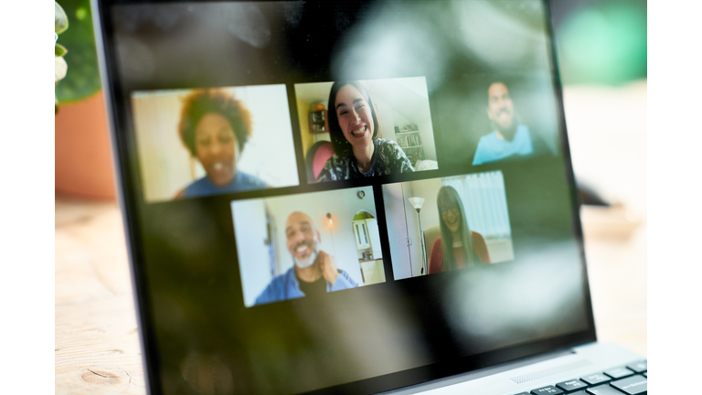 Smiling faces on laptop screen during video call