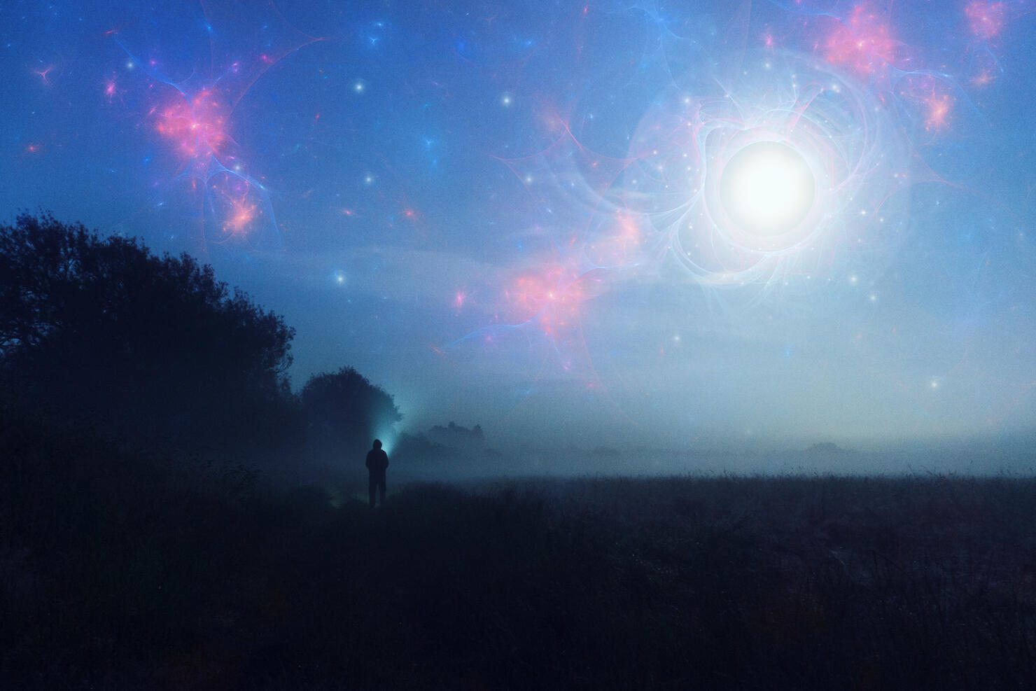 An alien invasion concept. Of glowing UFO's in the night sky with a figure looking up on a misty spooky night.