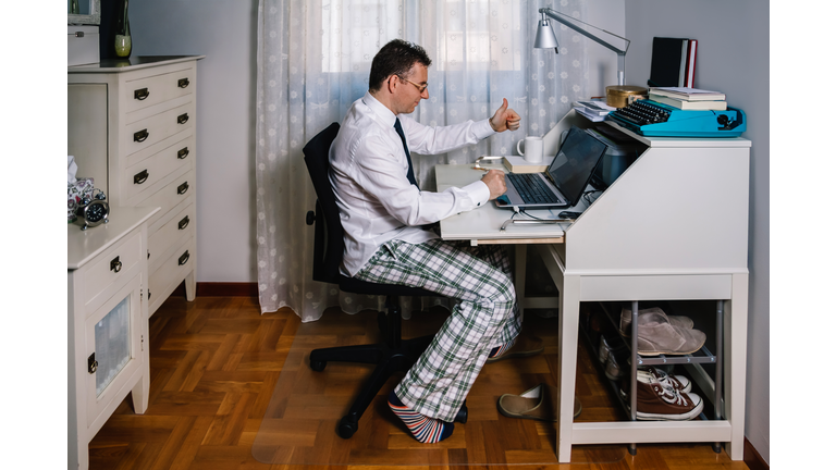 Man teleworking wearing shirt, tie and pajama pants