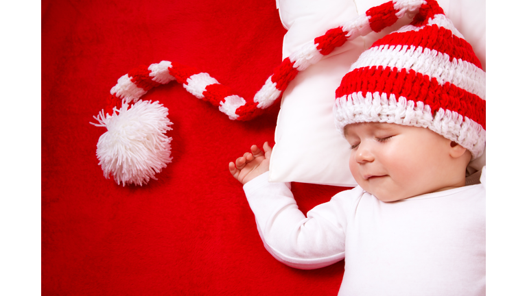 Sleepy baby on red blanket