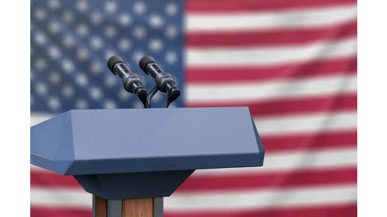 Flag of the United States at a press conference with microphones