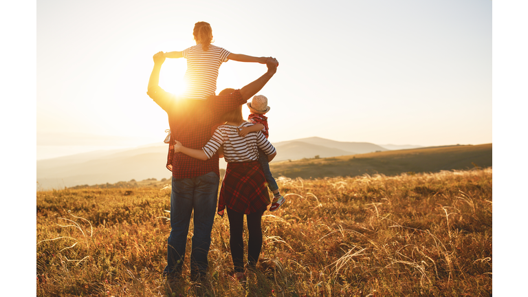 Happy family: mother, father, children son and daughter on sunset