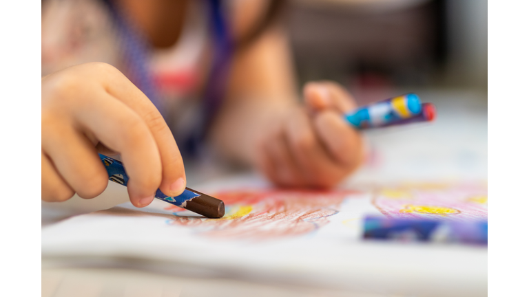 Close up of little hands coloring with Crayon