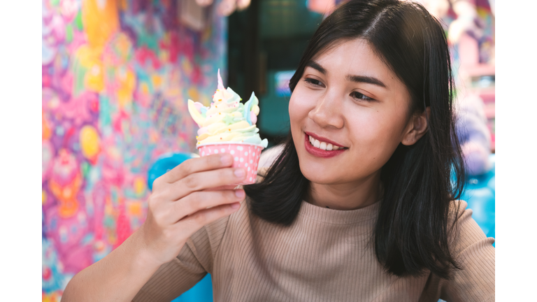 Portrait Of Woman Holding Cupcake And Smiling