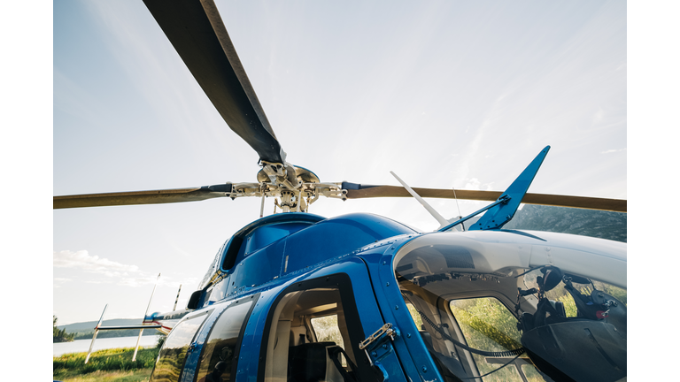 Looking up at the main rotor of a Bell 407 GXI helicopter on a sunny day