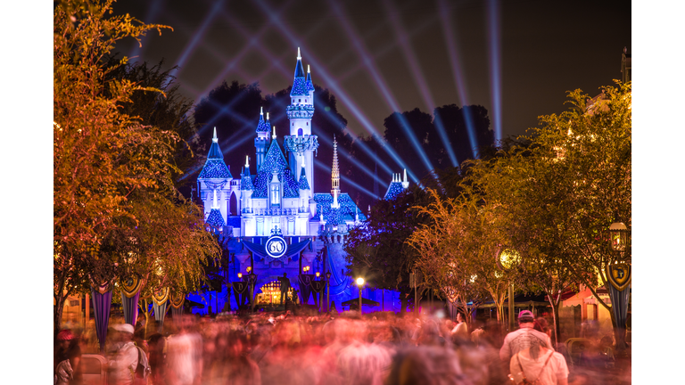 Disneyland 60th aniversary castle with people walking