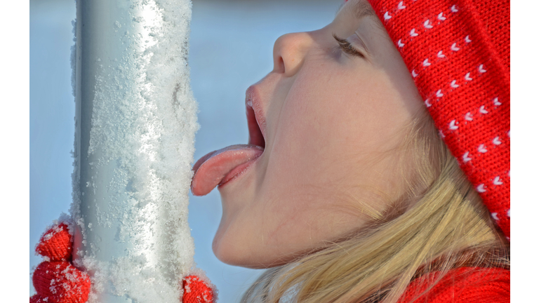 Girl licking flag pole