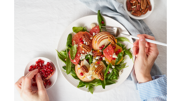 Woman Eating Fruits Citrus Salad With Nuts, Green Lettuce Leaves. Balanced Food. Top View