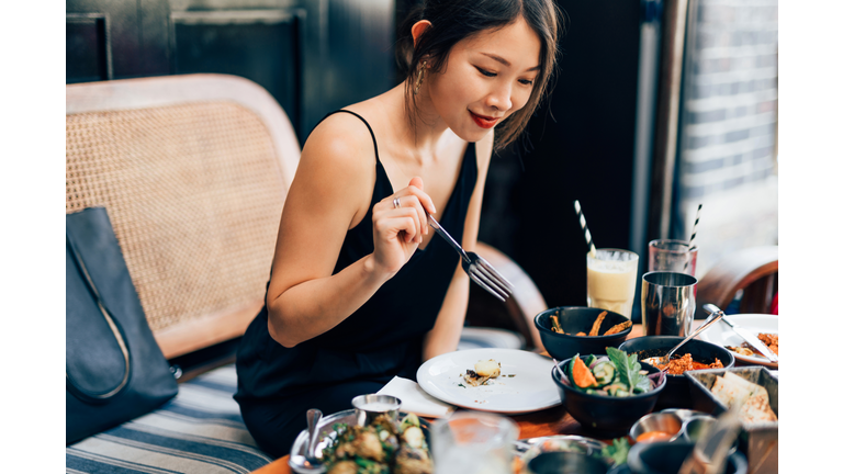 Young Woman Eating Food At The Restaurant