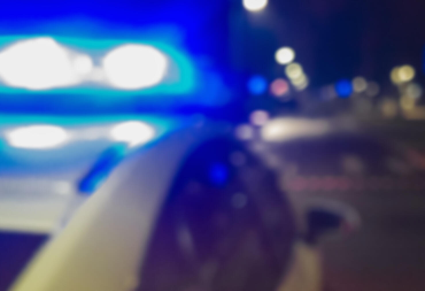 Lights of police car in night time. Night patrolling the city. Crime scene. Abstract blurry image for criminal news.