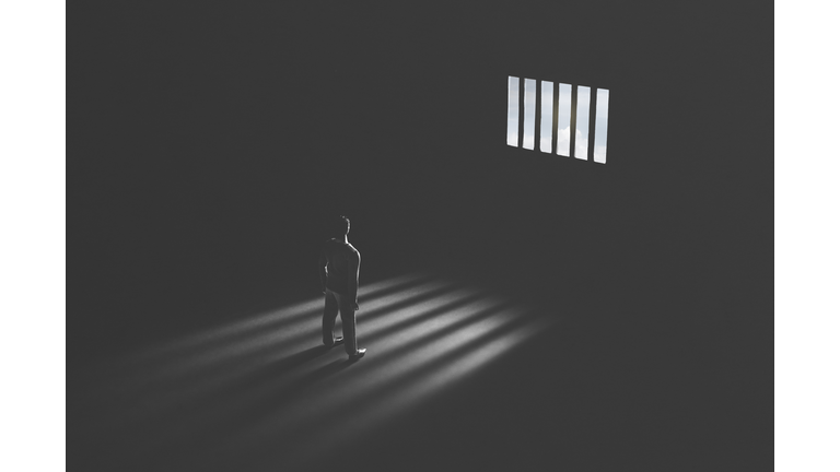 jail window light in a completely dark prison cell illuminated guilty man