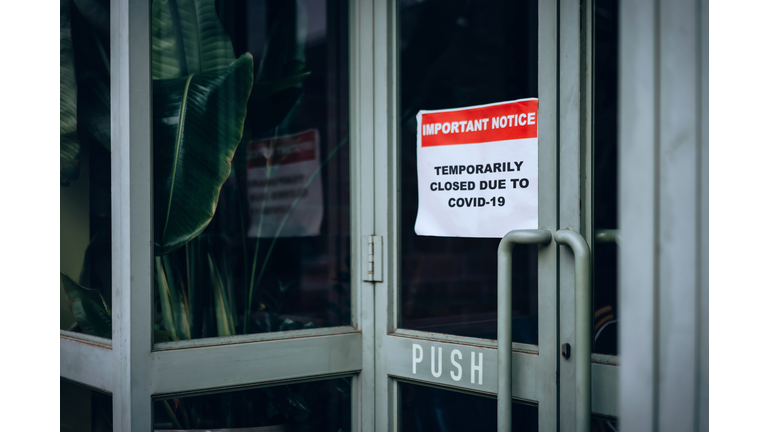 Business closed down signage putting onto a store window saying "Temporarily closed due to Covid-19" during the Covid-19 pandemic