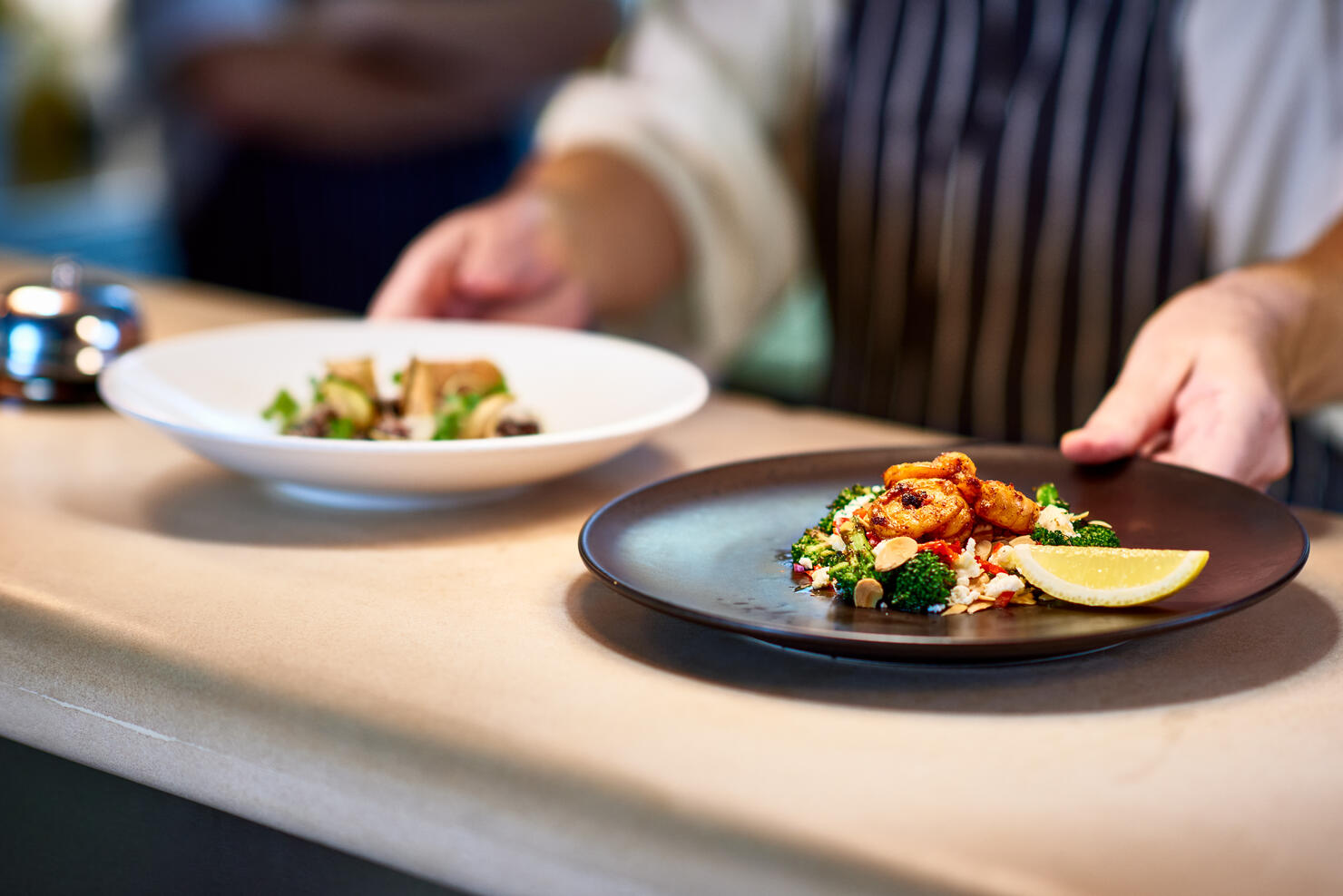 Chef placing dishes of prepared food on counter