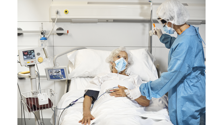 Doctor examining patient in ICU during COVID-19