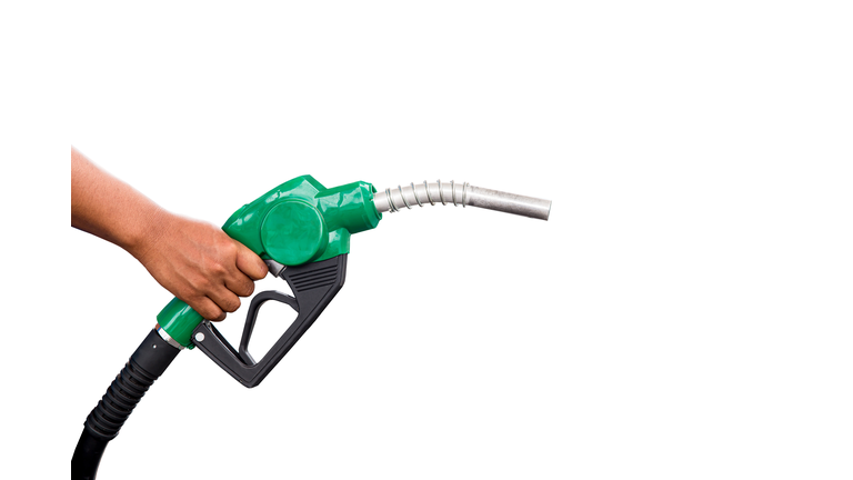 Hand holding gas nozzle with one last drop. A man holding a green gasoline nozzle on a white background. hands of men who were holding an automatic nozzle to make refill oil.