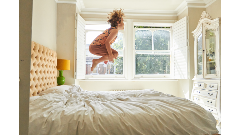 Child jumping on a bed