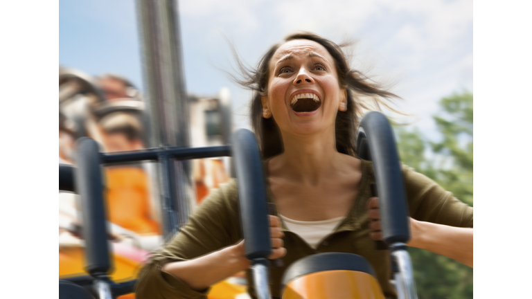 Young woman screaming on a rollercoaster