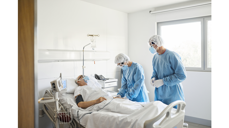 Doctors checking patient in ward during COVID-19