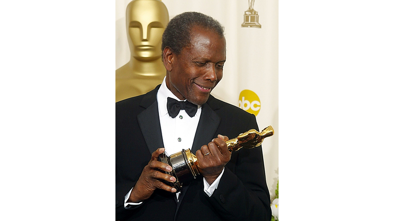 US actor Sidney Poitier admires his honorary Oscar