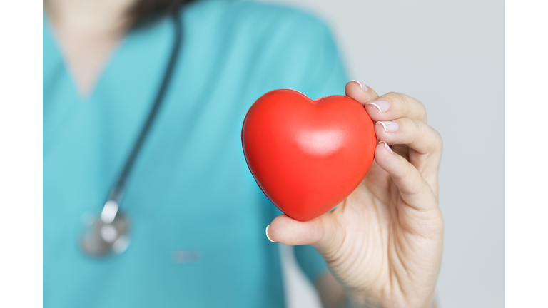 Doctor Holding Red Heart Shape in Hand