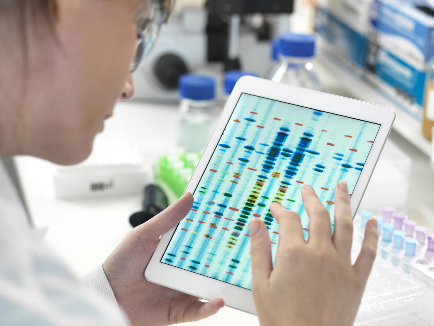 Female scientist examining DNA sequence results on digital tablet in laboratory