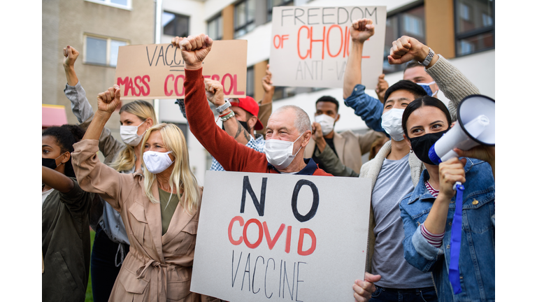 People with placards and posters on public demonstration, no covid vaccine concept.