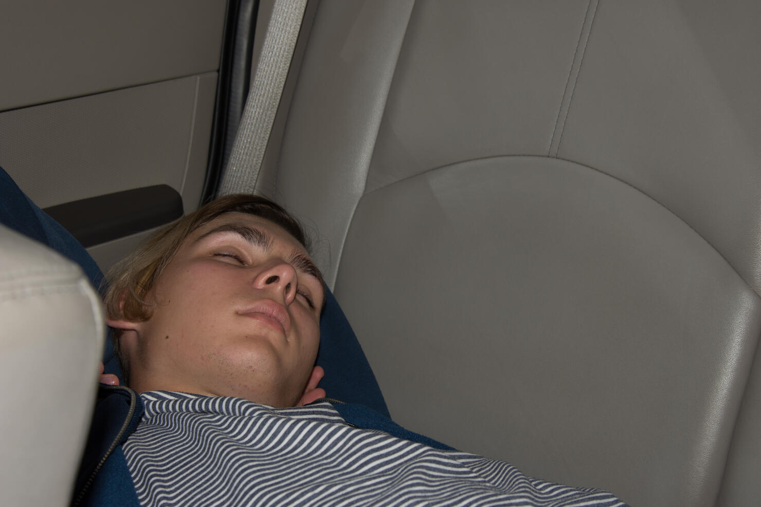 Young attractive guy sleeping in the car.