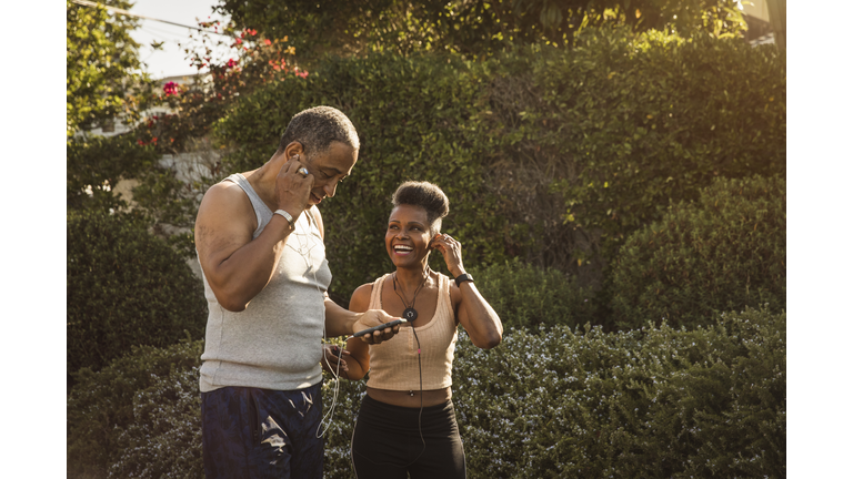 Couple listening to music on smart phone during exercise