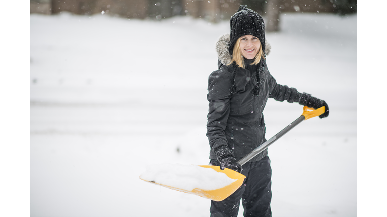 Shovelling snow off her driveway after a storm