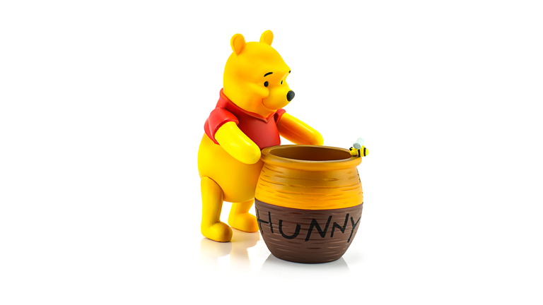 Figure of Winnie the Pooh and hunny pot.